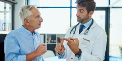 primary care physician talking with male patient about getting a PSA test to screen for prostate cancer.